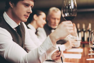 Emin yakışıklı sommelier şarap restoranda yaşlanma denetler. Şarap tadımı.