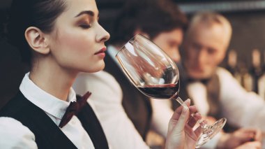 Deneyimli sommelier kadın şarap tadı restoranda araştırıyor. Şarap tadımı.