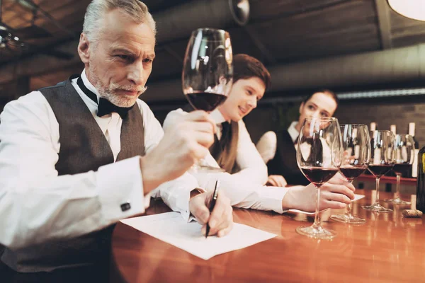 Confiante sommelier degustação de vinho no restaurante. Especialista em degustação faz notas . — Fotografia de Stock