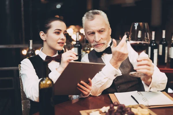 Experienced sommelier tells young girl about specifics of taste of red wine in restaurant. — Stock Photo, Image