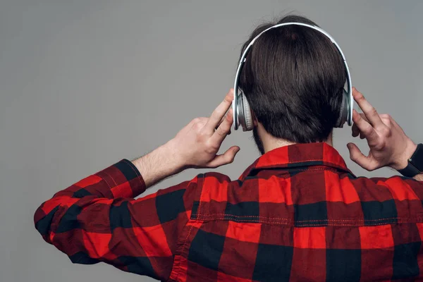 Vista trasera. Hombre escuchando música con auriculares — Foto de Stock