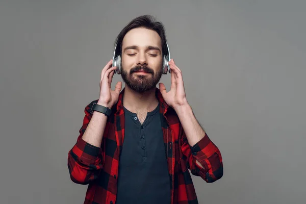 Szczęśliwy młody człowiek słuchanie muzyki w słuchawkach — Zdjęcie stockowe