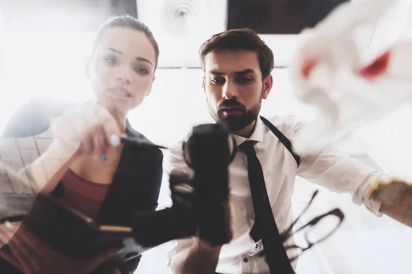 Private detective agency. Man and woman are looking at gun with magnifying glass. — Stock Photo, Image