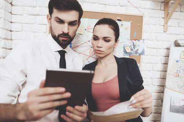 Prive-detective bureau. Man en vrouw zoekt op aanwijzingen op tablet in kantoor. — Stockfoto