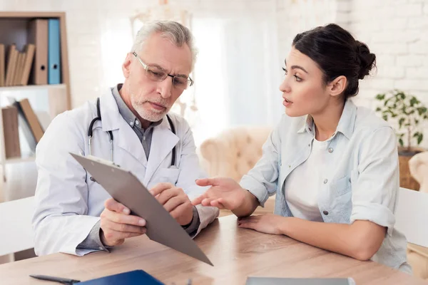 Médico con estetoscopio y paciente femenina en consulta. El doctor está diciendo diagnóstico . — Foto de Stock