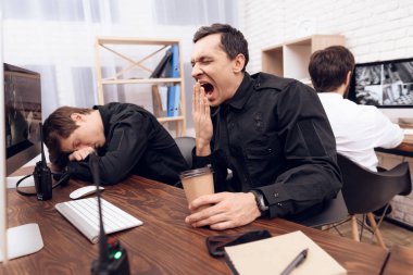Monitör yawns önünde oturan güvenlik görevlisi.