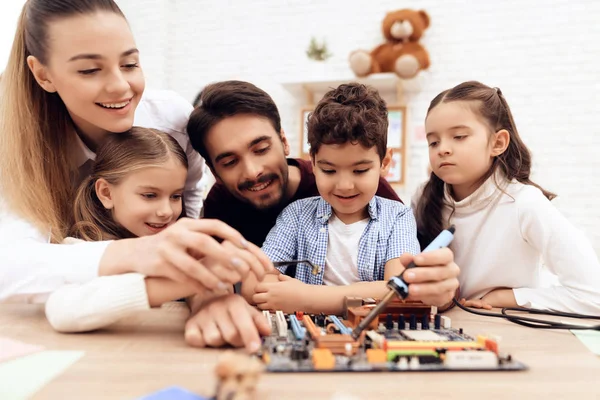 Kinder arbeiten gemeinsam mit der Lehrerin mit dem Lötkolben. — Stockfoto