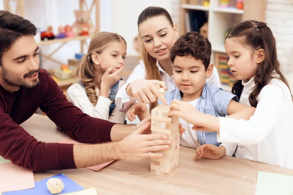 Los niños juegan Jenga con adultos . — Foto de Stock