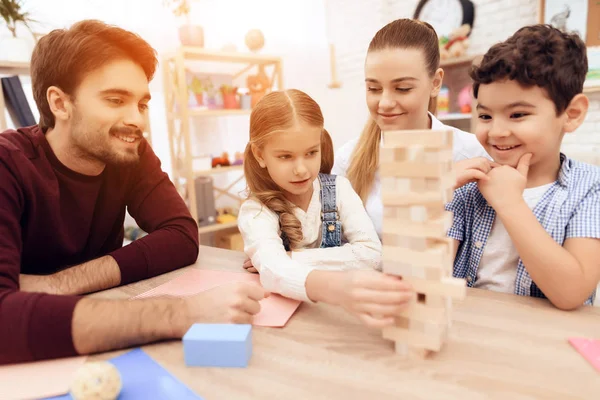 Kinder spielen Jenga mit Erwachsenen. — Stockfoto