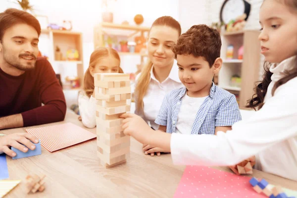 Los niños juegan Jenga con adultos . — Foto de Stock