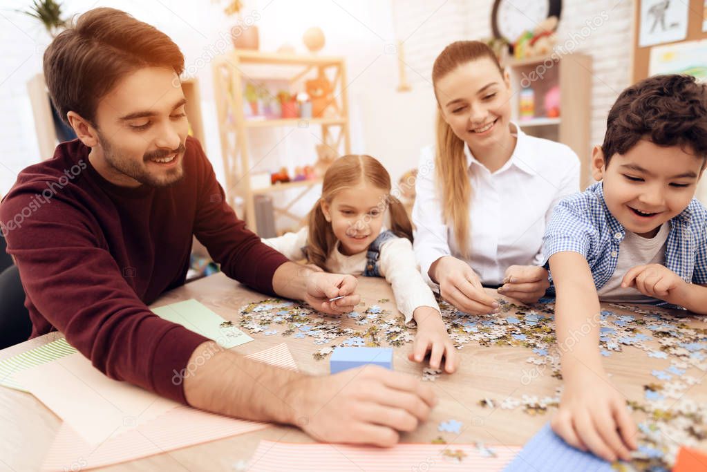 Children put puzzles together with adults.