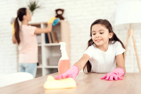 Mamma och dotter är rengöring hemma. Torka hyllorna och tabellen. — Stockfoto