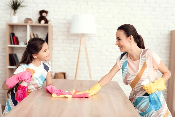 Uma mulher e uma menina estão posando com dinheiro para limpar o apartamento. Eles estão em casa . — Fotografia de Stock