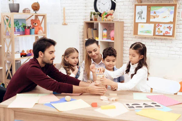 Crianças brincam de Jenga com adultos . — Fotografia de Stock