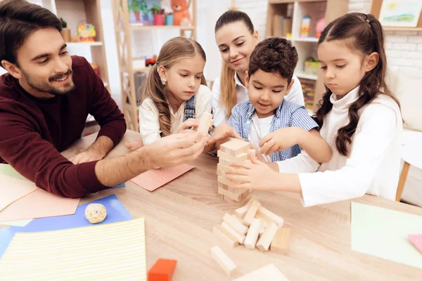 Bambini giocano a Jenga con gli adulti . — Foto Stock