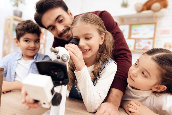 A child is looking through a microscope. — Stock Photo, Image