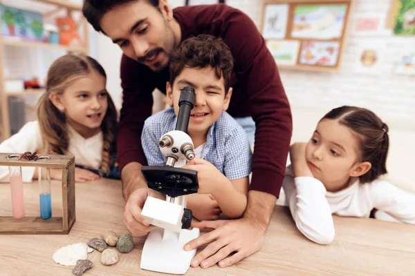 Ein Kind schaut durch ein Mikroskop. — Stockfoto