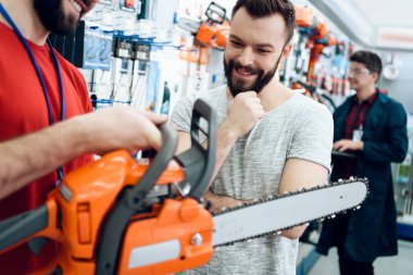 Sakallı gösteren istemci yeni chainsaw güç araçları deposundaki satıcısıdır.