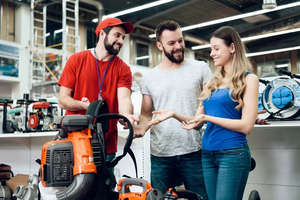 Coppia di clienti stanno discutendo il ventilatore del foglio con il commesso nel deposito degli attrezzi elettrici . — Foto Stock