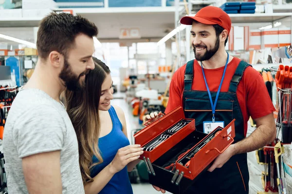 Vendedor está mostrando par de clientes nova caixa de ferramentas na loja de ferramentas elétricas . — Fotografia de Stock