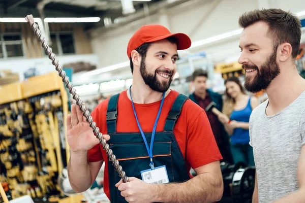 Salesman показує бородатий клієнт новий гігантський дриль в магазині електроінструментів . — стокове фото