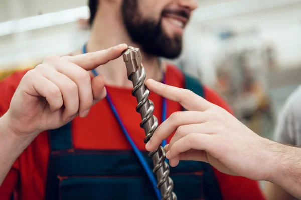 Близько. Salesman показує бородатий клієнт новий гігантський дриль в магазині електроінструментів . — стокове фото