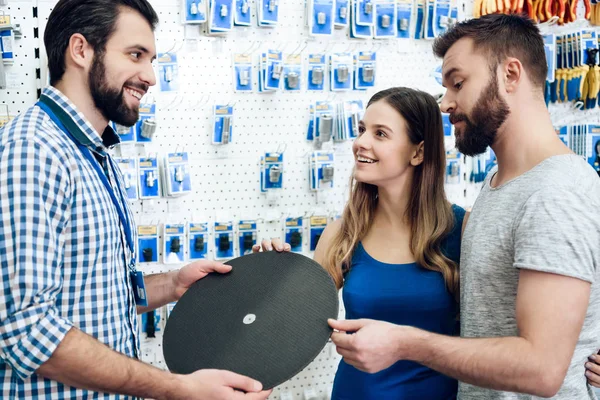 Πωλητής δείχνει δυο πελάτες νέα τροχιστικού στο power εργαλεία αποθήκευσης. — Φωτογραφία Αρχείου