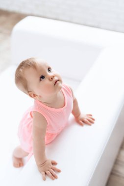 Üstten görünüm. Yeni doğan bebek pembe kanepede giyinmiş.