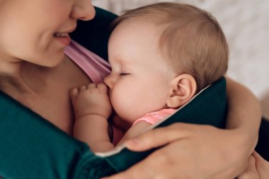 Yakın çekim. Uyuyan bebek tutan anne.