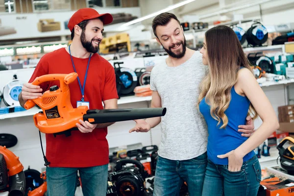 Πωλητής δείχνει δυο πελάτες νέα φυσητήρας φύλλων στο power εργαλεία αποθήκευσης. — Φωτογραφία Αρχείου