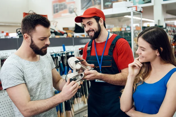 Salesman показує кілька клієнтів нового пристрою з відсмоктувачами в магазині електроінструментів . — стокове фото