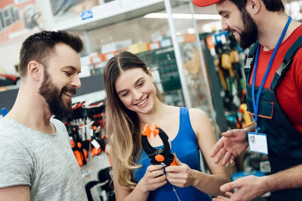 Vendedor está mostrando par de clientes novo alicate na loja de ferramentas elétricas . — Fotografia de Stock