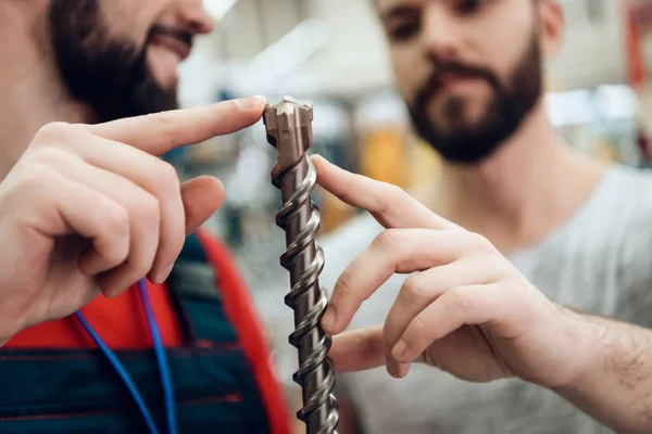 Близько. Salesman показує бородатий клієнт новий гігантський дриль в магазині електроінструментів . — стокове фото