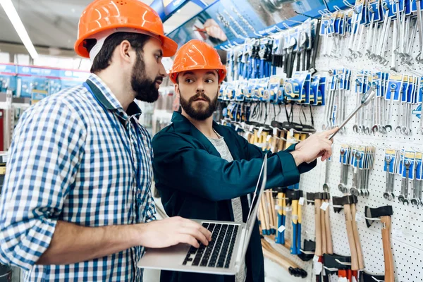 Due venditori stanno controllando la selezione delle attrezzature nel negozio di utensili elettrici . — Foto Stock