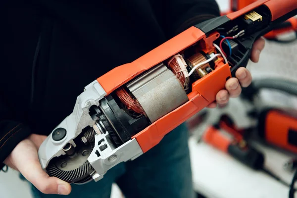 Närbild. Säljare poserar med nya vinkelslip i power tools butik. — Stockfoto