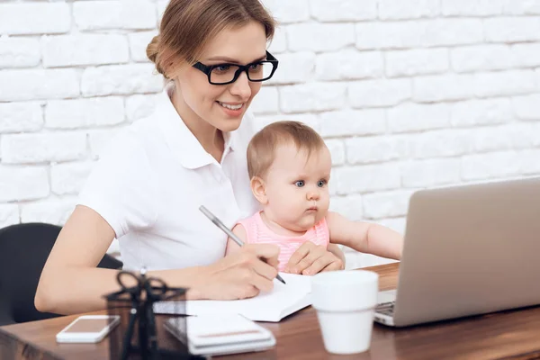 Young business lady try to work with newborn baby. — Stock Photo, Image