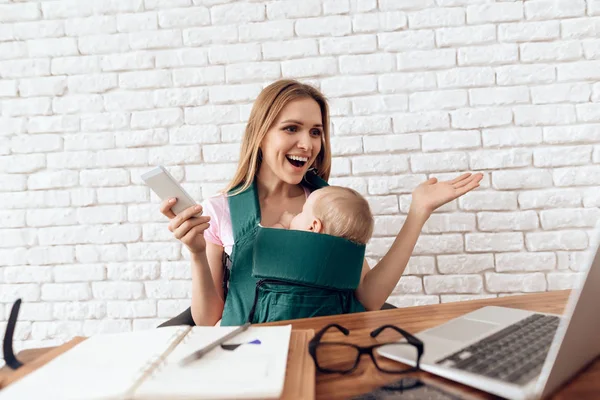 Sorrindo mulher de negócios trabalhando com bebê — Fotografia de Stock