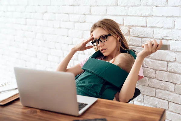 Moe zakenvrouw met pasgeboren proberen om te werken. — Stockfoto