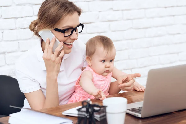 Jovem empresária tentar trabalhar com bebê bonito . — Fotografia de Stock