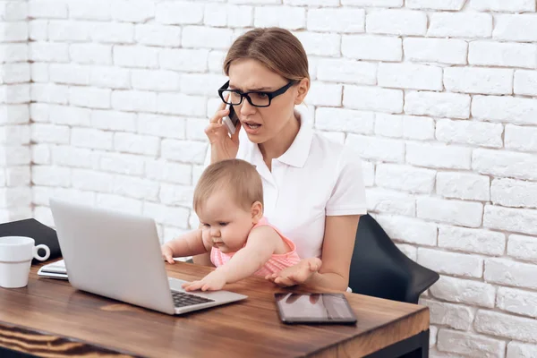 Youn business lady try to work with baby — Stock Photo, Image