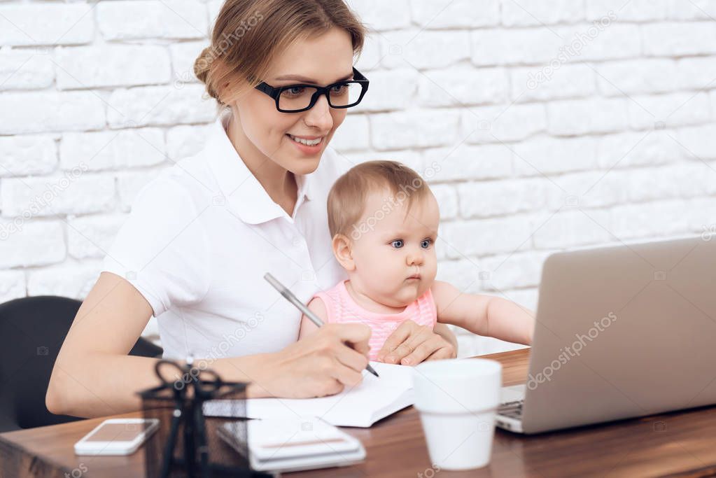 Young business lady try to work with newborn baby.