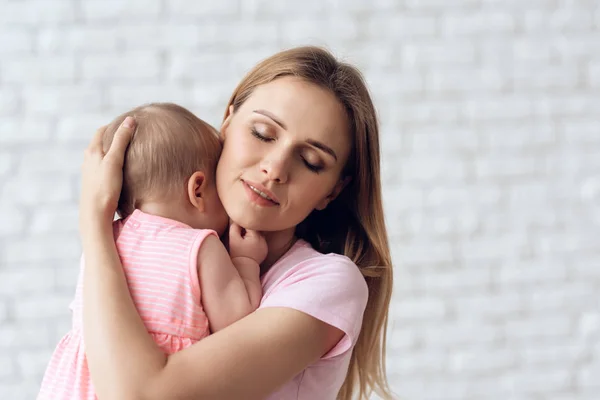 Χαριτωμένο μωρό αγκαλιάζει με εύθυμη νεαρή μητέρα. — Φωτογραφία Αρχείου