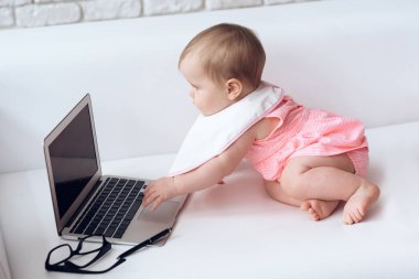 Oyun dizüstü küçük bebek pembe giymiş.