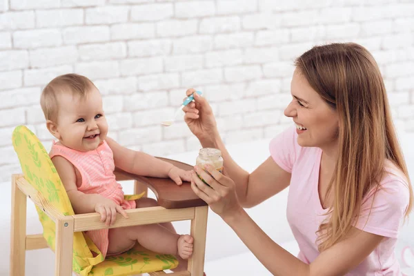 Mãe sorridente com purê de alimentação bebê sorridente . — Fotografia de Stock