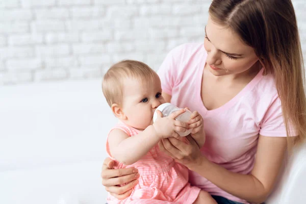 Νέοι μητέρα μπουκάλι γάλα σίτιση το μωρό σπίτι. — Φωτογραφία Αρχείου