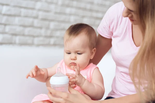 Mãe tentar alimentar bebê mamadeira de leite em casa . — Fotografia de Stock