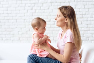 Şirin bebek genç gülümseyen anne ile sarılma