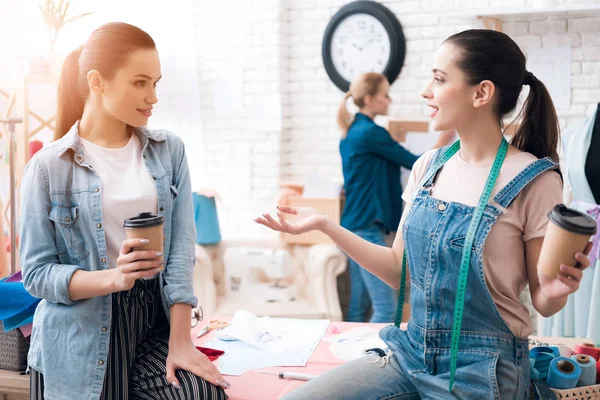 의류 공장에 세 여자입니다. 두 명은 커피 얘기 하 고 웃 고 마시고. — 스톡 사진