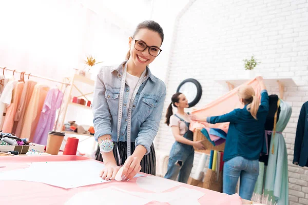 Drei Frauen in einer Bekleidungsfabrik. sie messen und schneiden aus. — Stockfoto