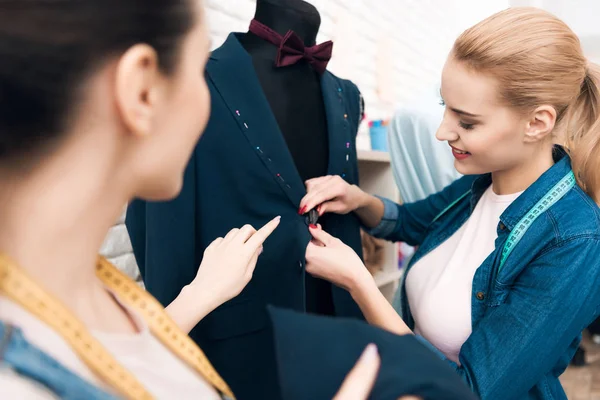 Dos chicas en la fábrica de prendas de vestir diseñando chaqueta de traje de hombre nuevo . —  Fotos de Stock